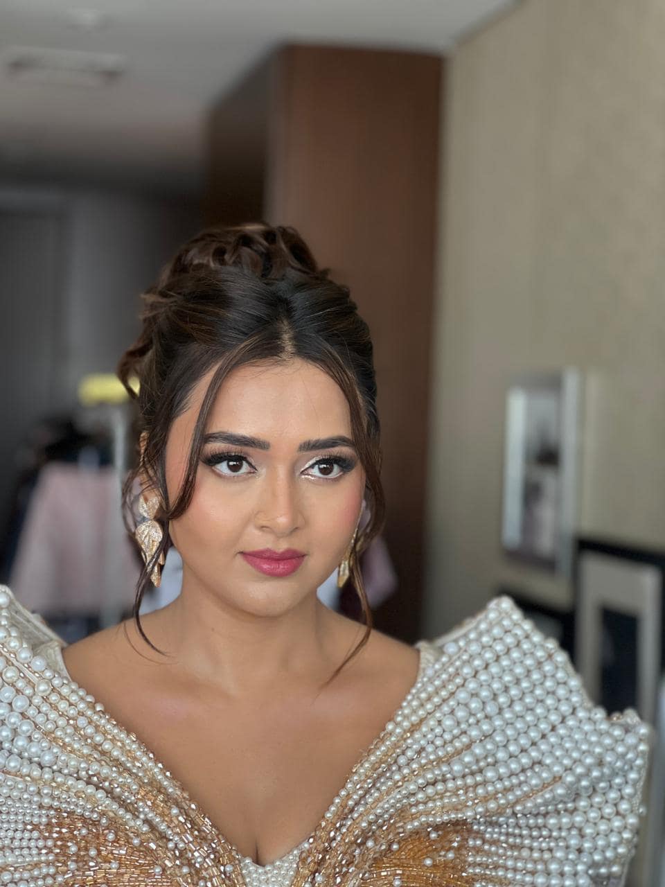 Bride in pearl jewellery wearing warm bridal makeup with a sculpted updo