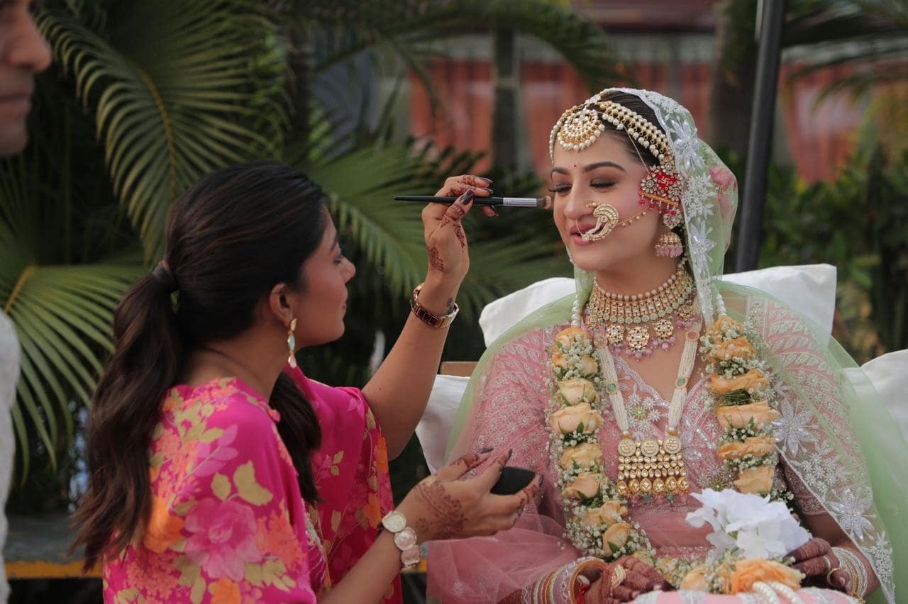 Sheetal Mukhida applying bridal makeup outdoors, blending base in natural daylight
